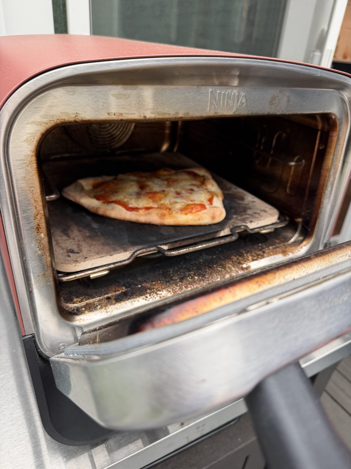 Pesto pizza topped with torn mozzarella, ready to launch